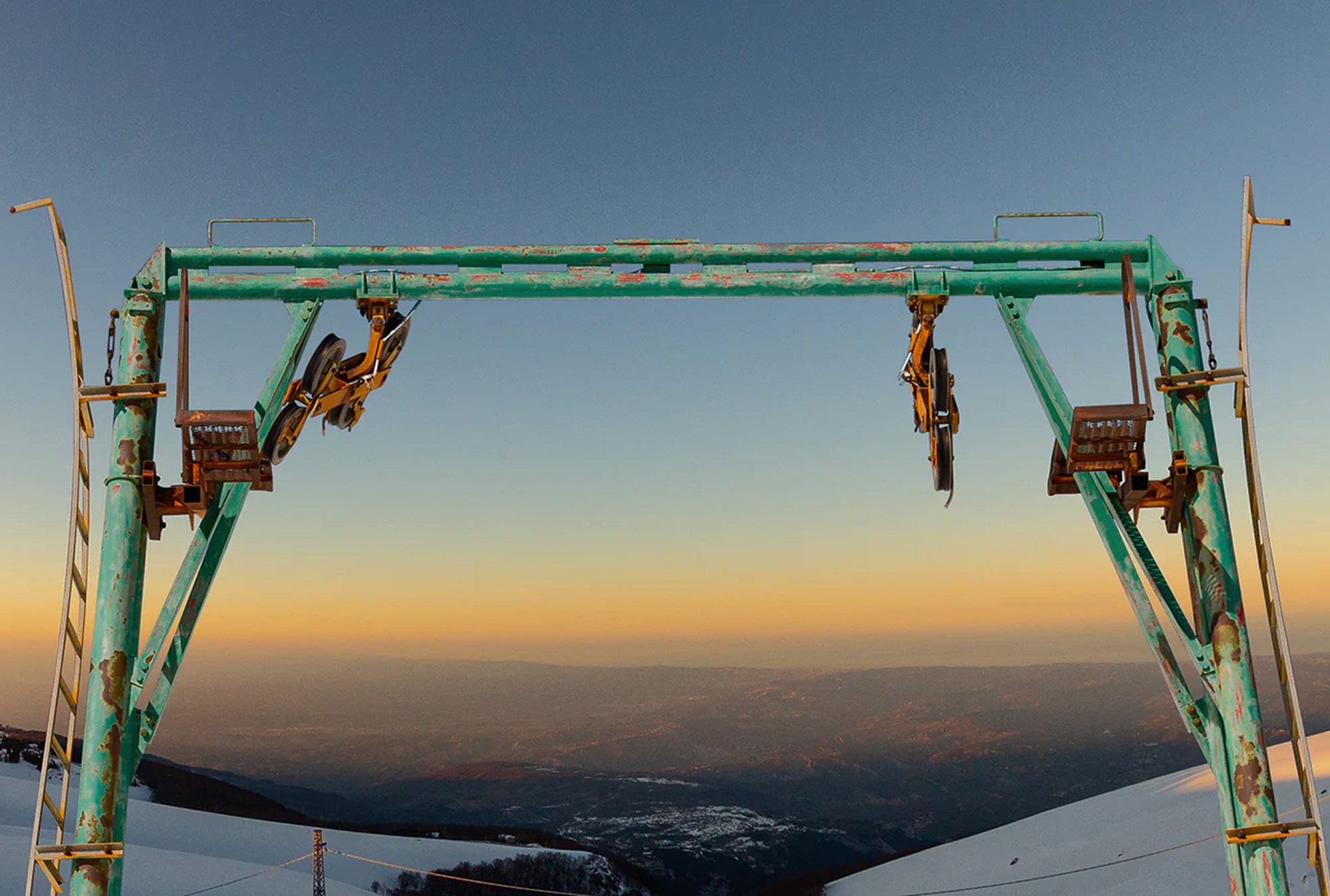 Abandoned ski lift structure at sunset in a former Italian ski resort.