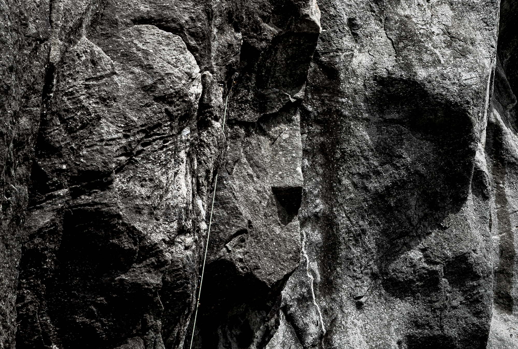 Climbers ascending steep rock terrain in Corsica