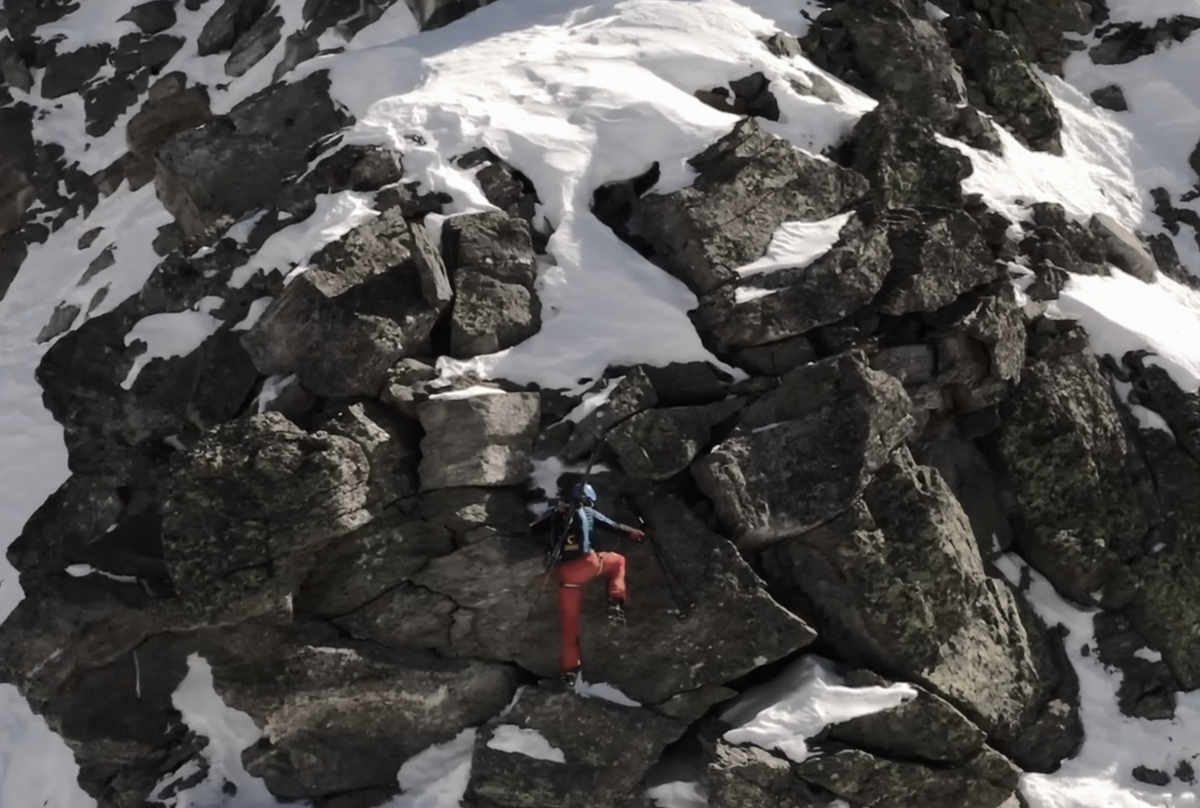 Denis Trento moving through rocky alpine terrain in winter conditions.