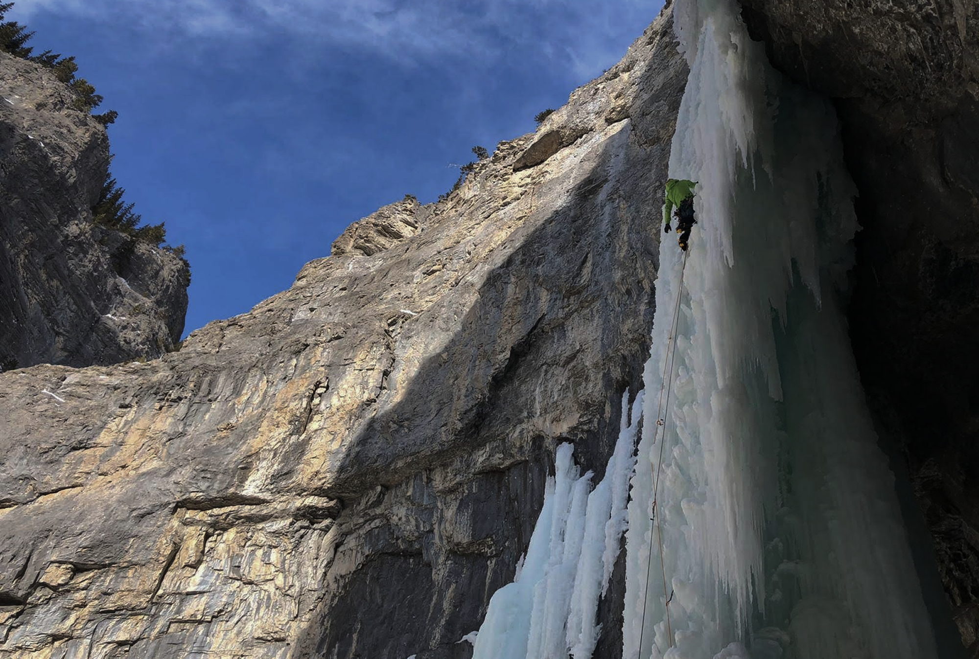 Climber ascending a frozen waterfall in the Canadian Rockies.