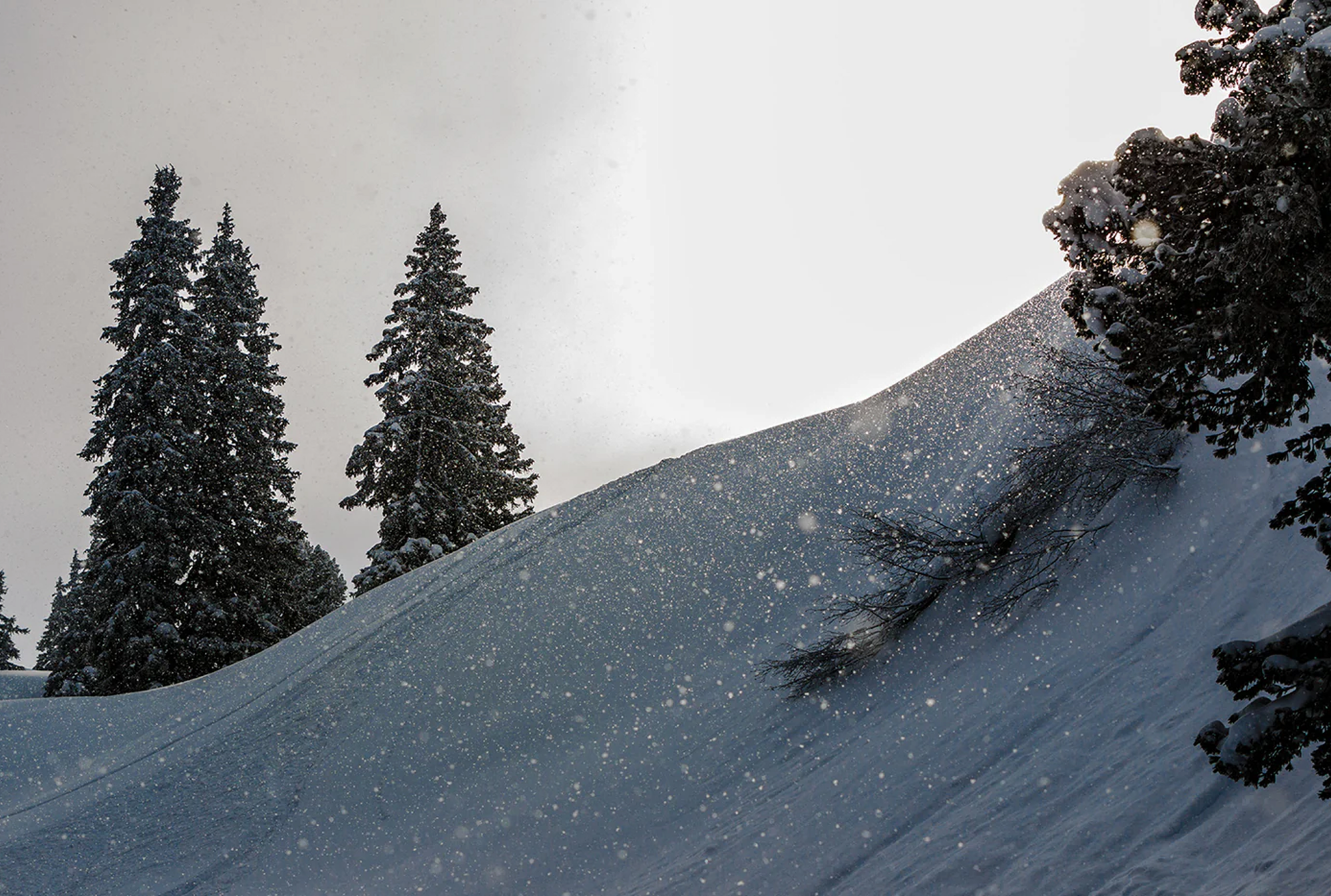Snow-covered alpine slope during snowfall in the Alps