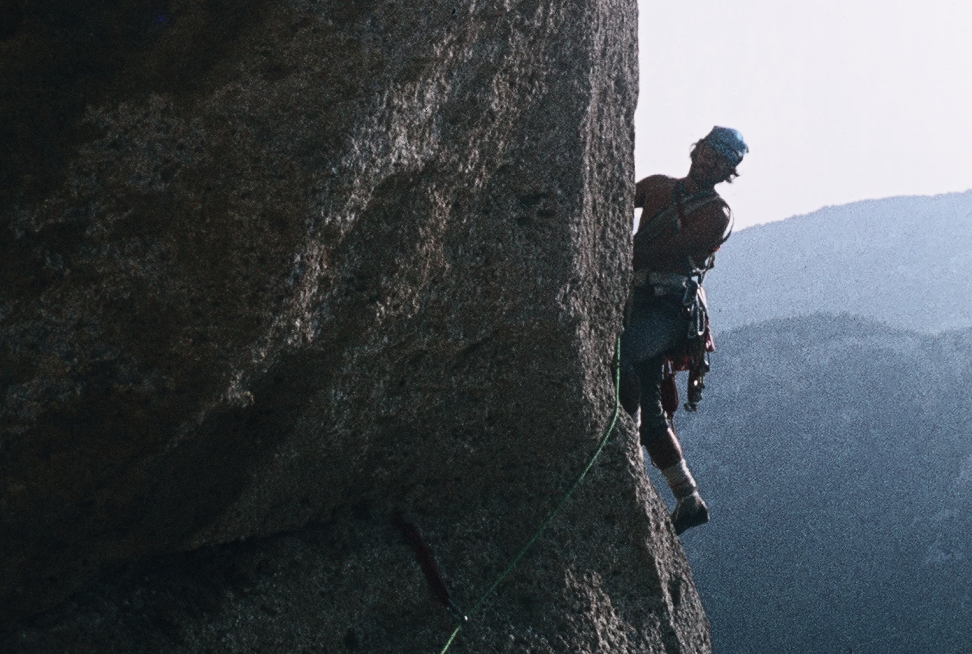 Guido Azzalea climbing a steep rock wall during the early years of sport climbing in Aosta Valley.