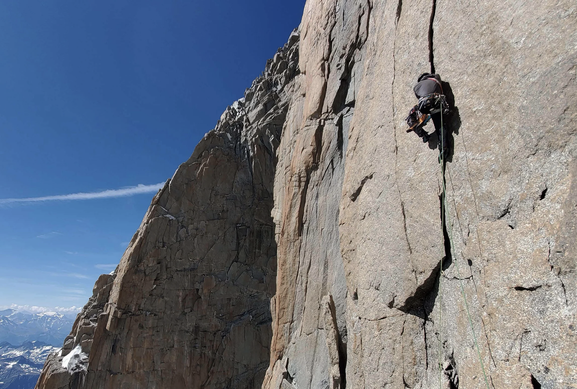 Climber ascending a snow ridge during the Bonatti Route on the Matterhorn north face.