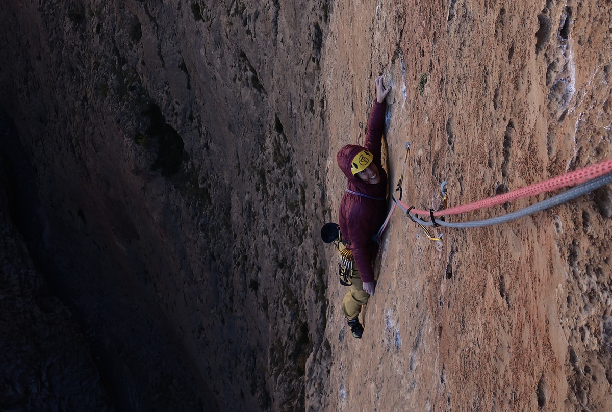 Silvia Loreggian climbing a vertical limestone wall during an expedition in Taghia, Morocco.