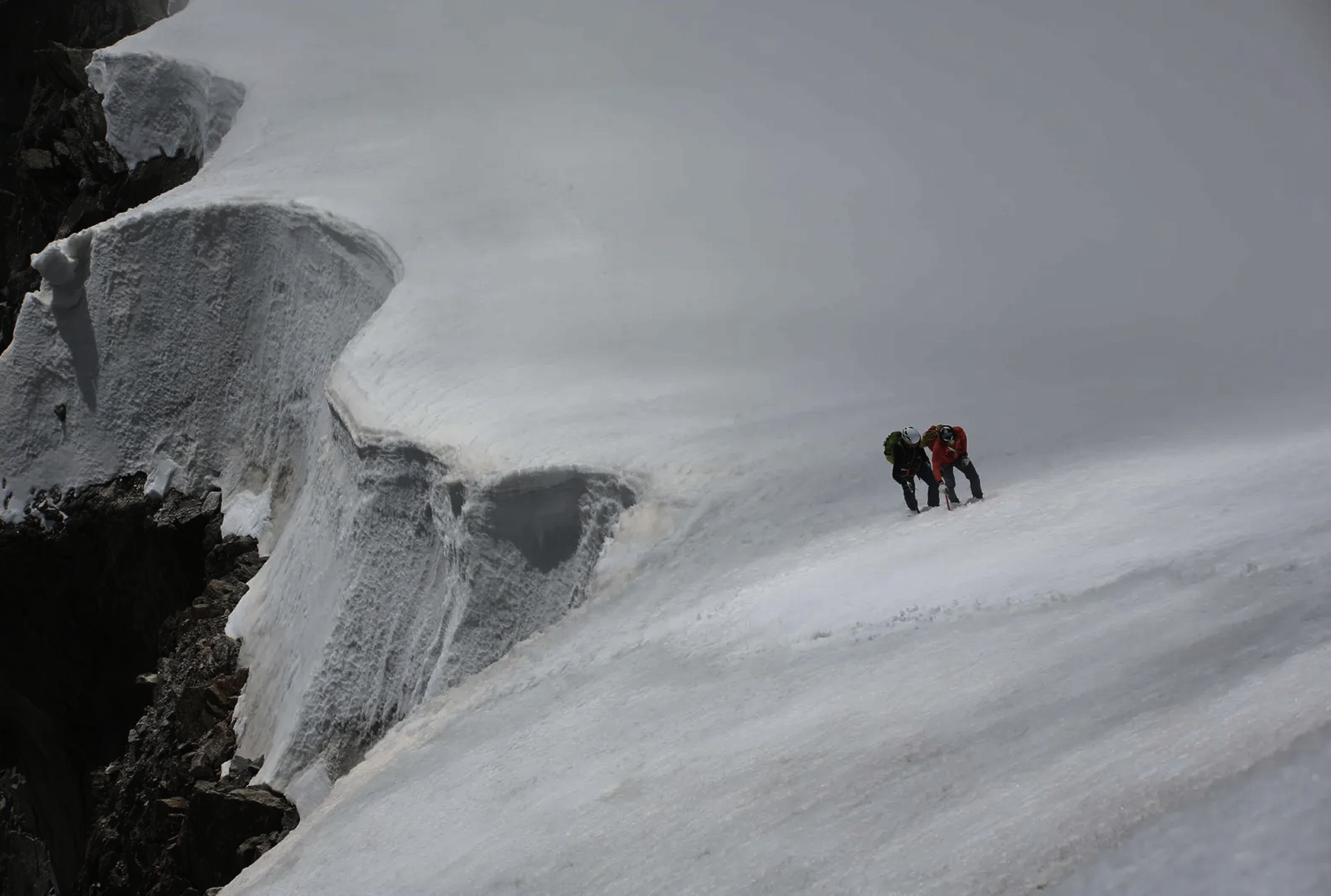 François Cazzanelli and Andreas Steindl moving along a snow ridge on the Peuterey Integral.