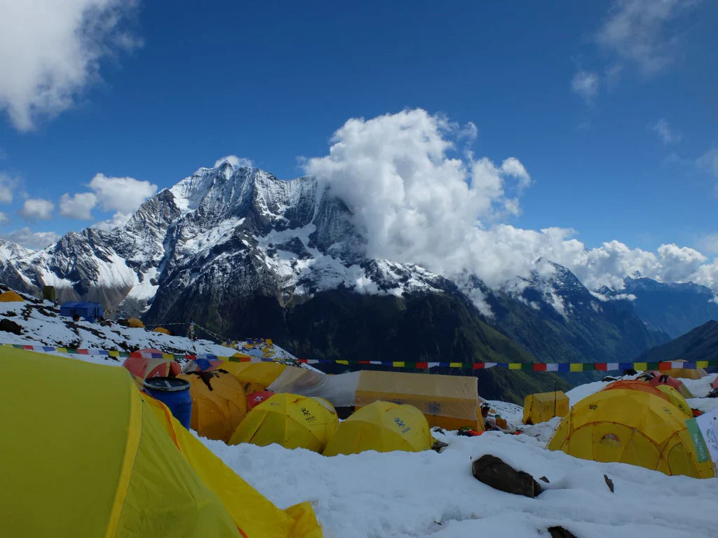 Expedition tents below snow-covered Himalayan peaks near Samagoan, Nepal.