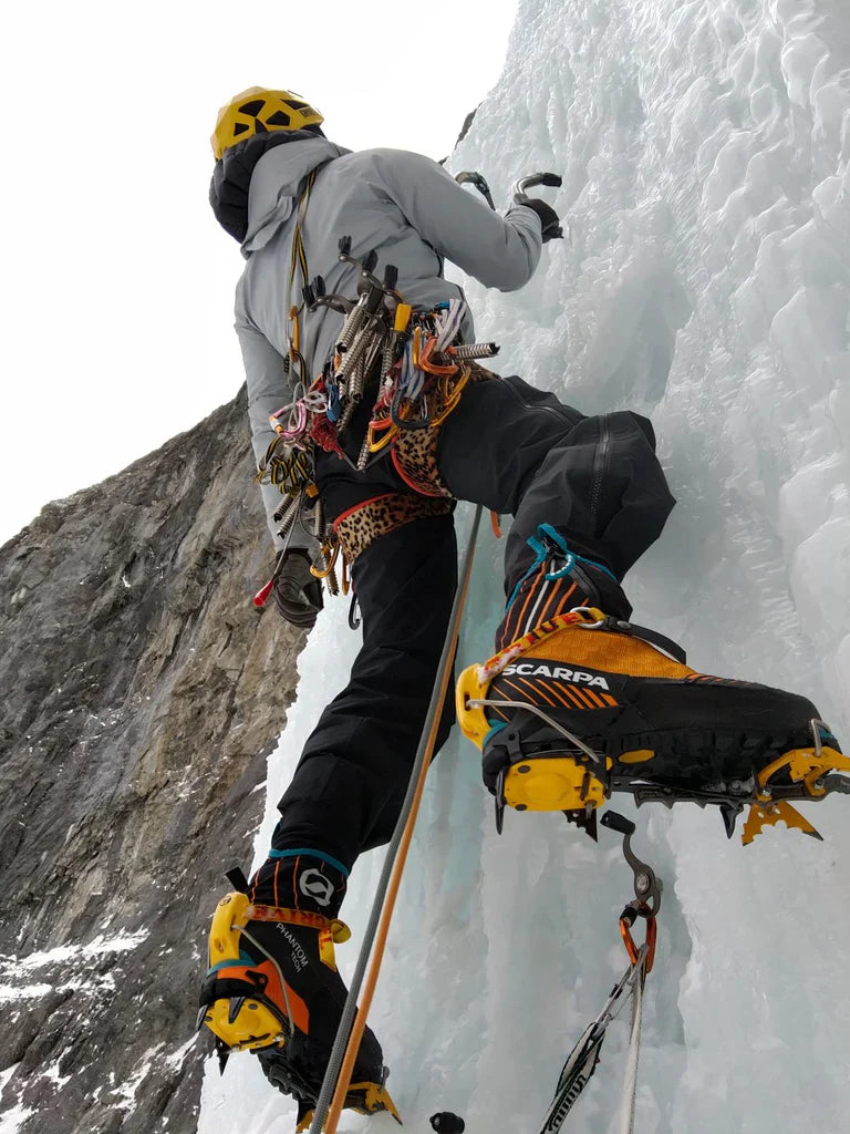 Charlotte Barrér using crampons and ice axes on a frozen waterfall in Canada.