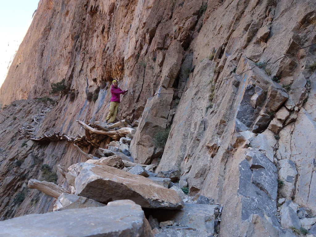 Silvia Loreggian approaching a limestone wall on rocky ledges in Taghia.