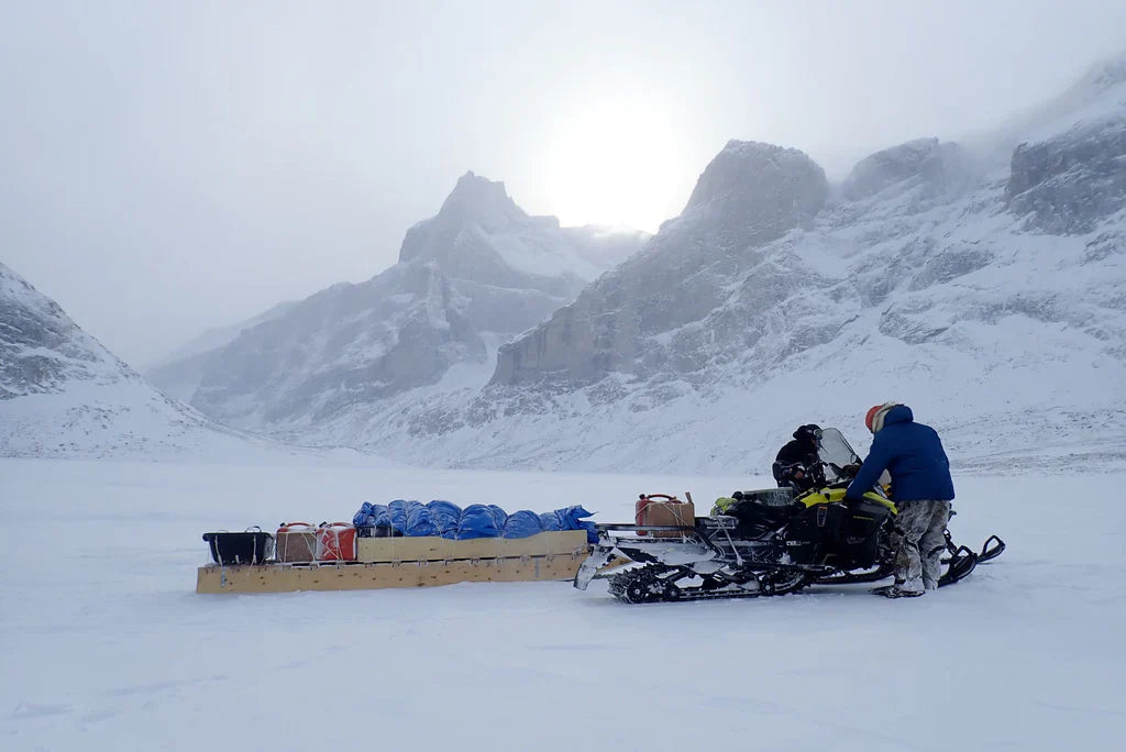 Snowmobile transporting expedition equipment across Sam Ford Fiord