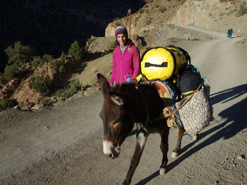 Silvia Loreggian with a loaded donkey carrying climbing equipment on the approach to Taghia.