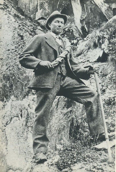 Historical portrait of an alpinist holding a wooden shaft ice axe.