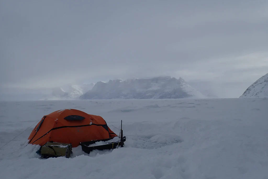 Expedition tent surrounded by snow and Arctic landscape on Baffin Island