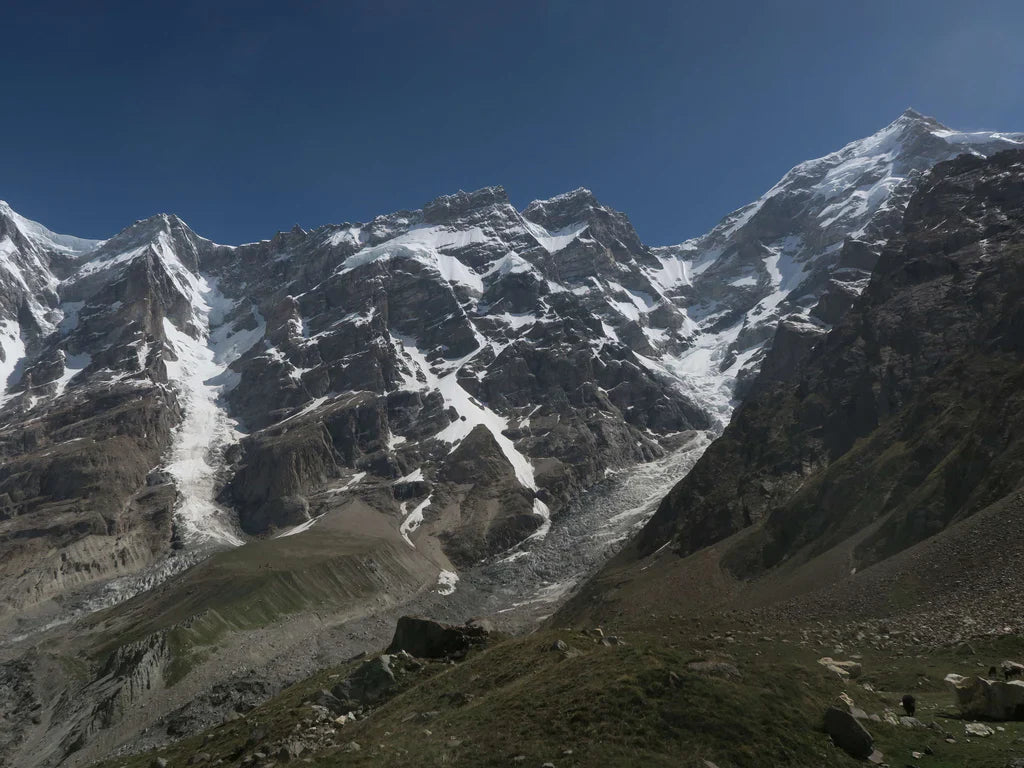 Steep rock and snow faces rising above glacial terrain in the Karakoram.