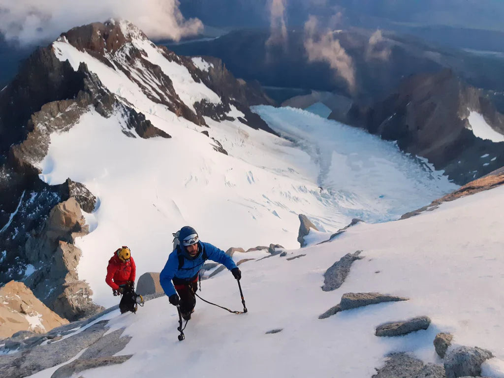 Silvia Loreggian and Stefano Ragazzo ascending a snow slope below the Fitz Roy massif in Patagonia.