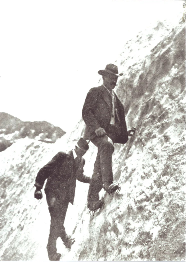 Early alpinists ascending steep ice slopes using pioneering crampon technology.