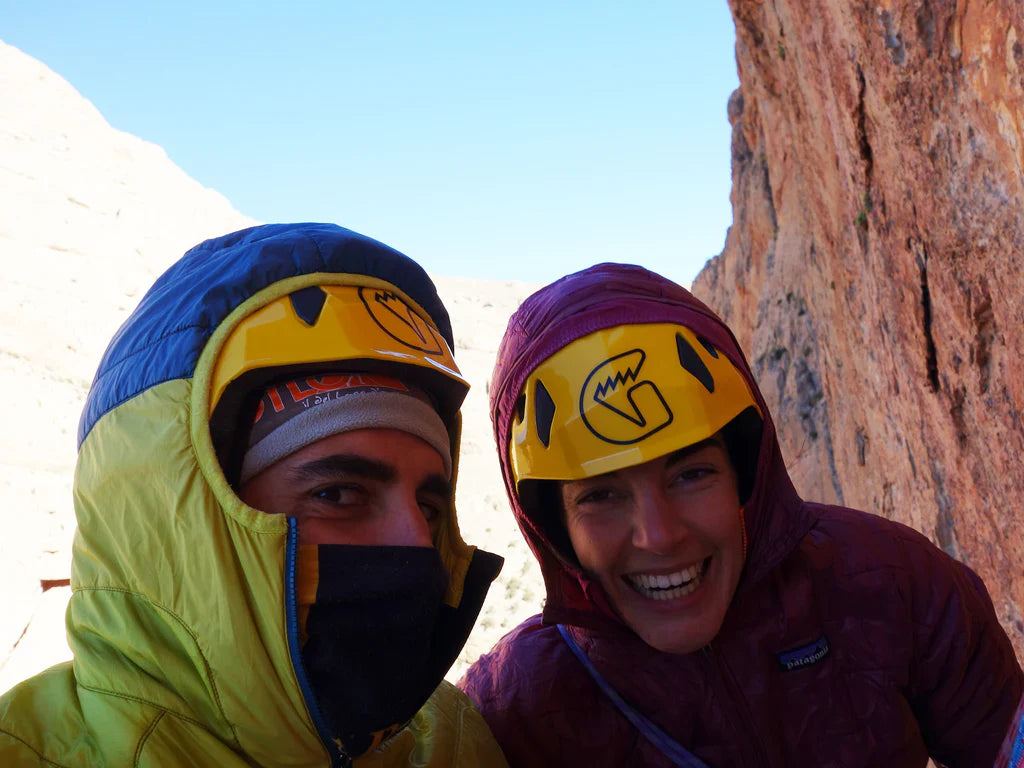 Silvia Loreggian and Stefano Regazzo wearing Grivel helmets at the base of a limestone wall in Taghia